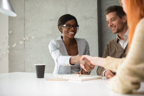 A female financial planner shaking hands with a client in Virginia